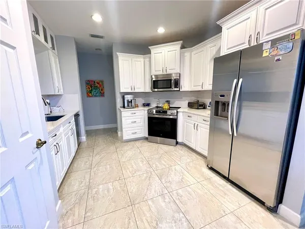 a kitchen with stainless steel appliances granite countertop a refrigerator stove and sink