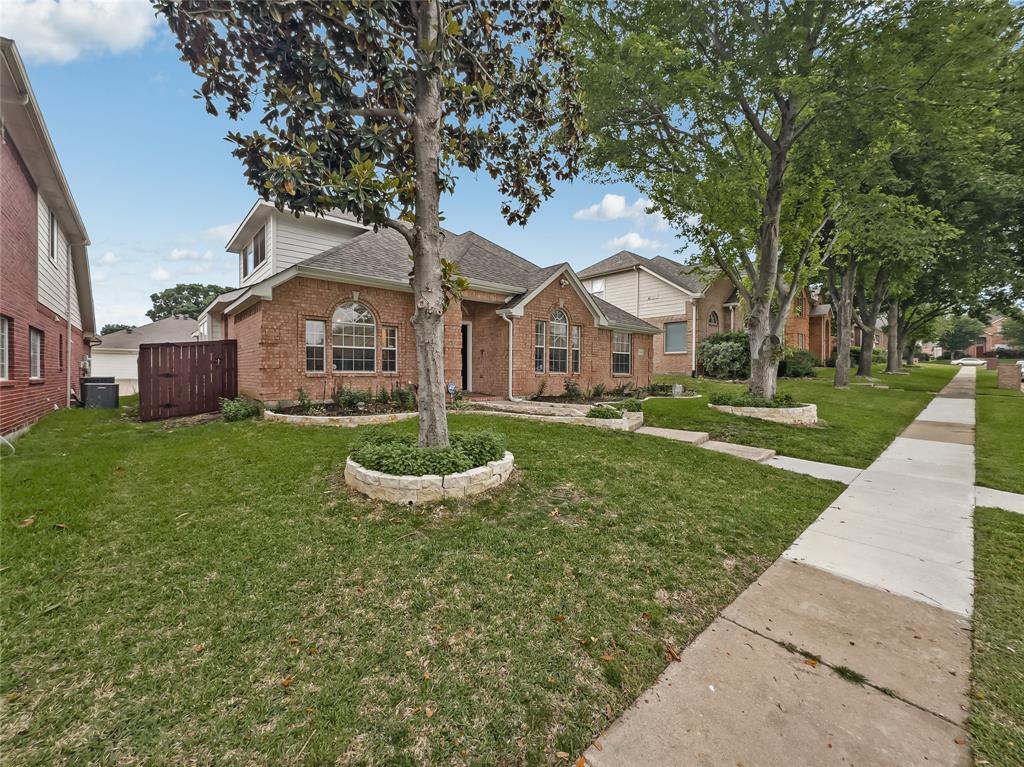 3008 Devlin Ridge Drive Plano, TX 75025 - Photo 2 of 24 Brick facade with arched windows, mature landscaping, and an established sidewalk
