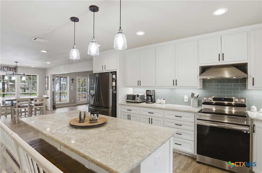 642 Phantom Rider Trail Spring Branch, TX 78070 - Photo 12 of 41 a kitchen with a stove a sink a stove and chairs