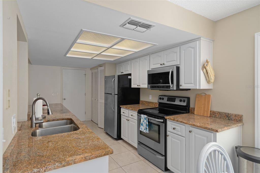 6147 Turnburry Court Spring Hill, FL 34606 - Photo 17 of 31 a kitchen with stainless steel appliances granite countertop a sink stove and refrigerator