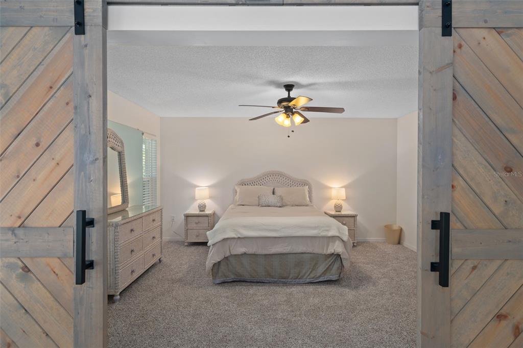 6147 Turnburry Court Spring Hill, FL 34606 - Photo 19 of 31 a bedroom with a bed and a chandelier