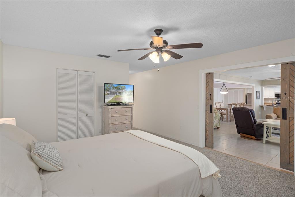 6147 Turnburry Court Spring Hill, FL 34606 - Photo 20 of 31 a bedroom with a bed and a chandelier
