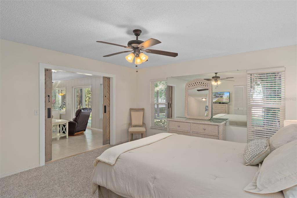 6147 Turnburry Court Spring Hill, FL 34606 - Photo 21 of 31 a bedroom with a bed and a chandelier