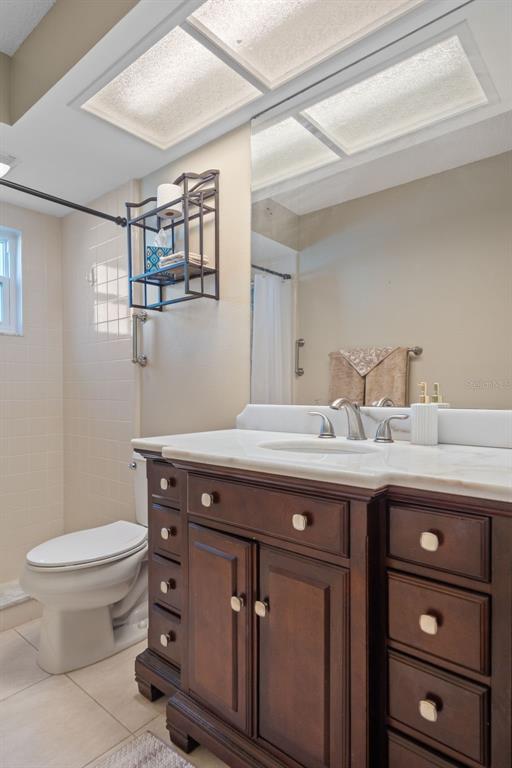 6147 Turnburry Court Spring Hill, FL 34606 - Photo 22 of 31 a bathroom with a granite countertop sink a toilet and a mirror