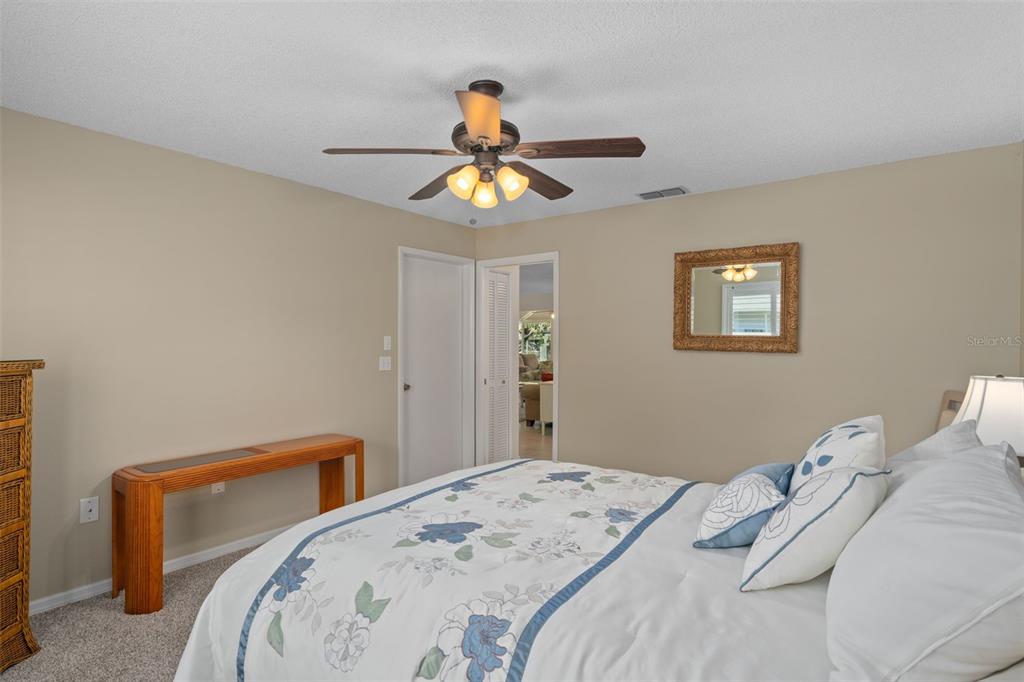 6147 Turnburry Court Spring Hill, FL 34606 - Photo 24 of 31 a bedroom with a bed and a chandelier