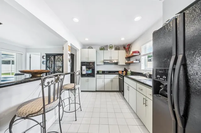 a kitchen with stainless steel appliances a refrigerator sink and cabinets