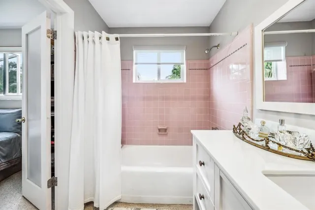 a bathroom with a tub sink and mirror