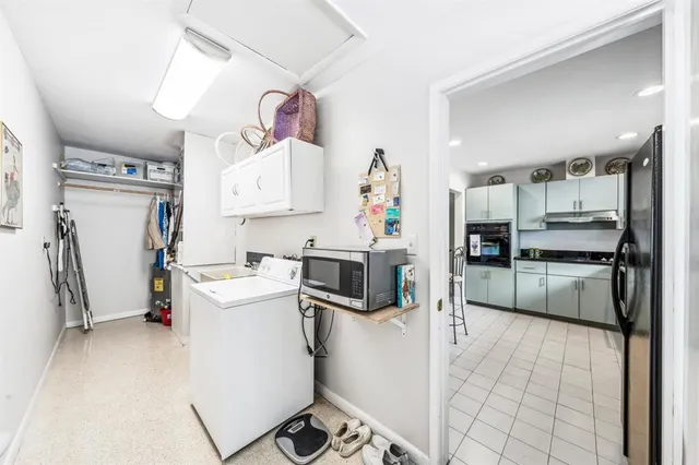 a kitchen with a refrigerator sink and white cabinets