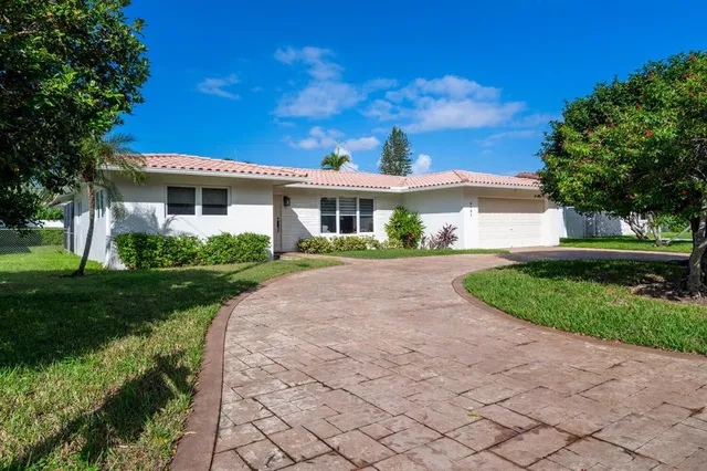a front view of a house with a garden and plants