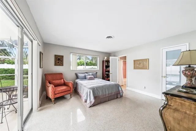 a bedroom with furniture and a large window