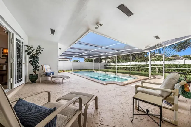 a living room with patio furniture and a large window