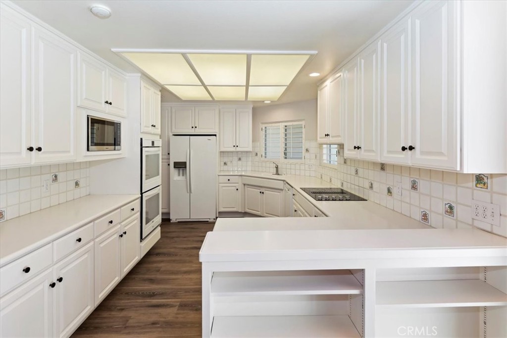 1507 Weston Way Riverside, CA 92506 - Photo 16 of 55 a kitchen with white cabinets and stainless steel appliances