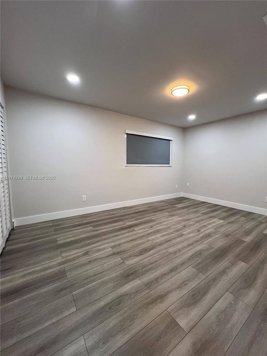 3826 Southwest 107th Avenue, Unit 22 Miami, FL 33165 - Photo 13 of 18 an empty room with wooden floor and windows