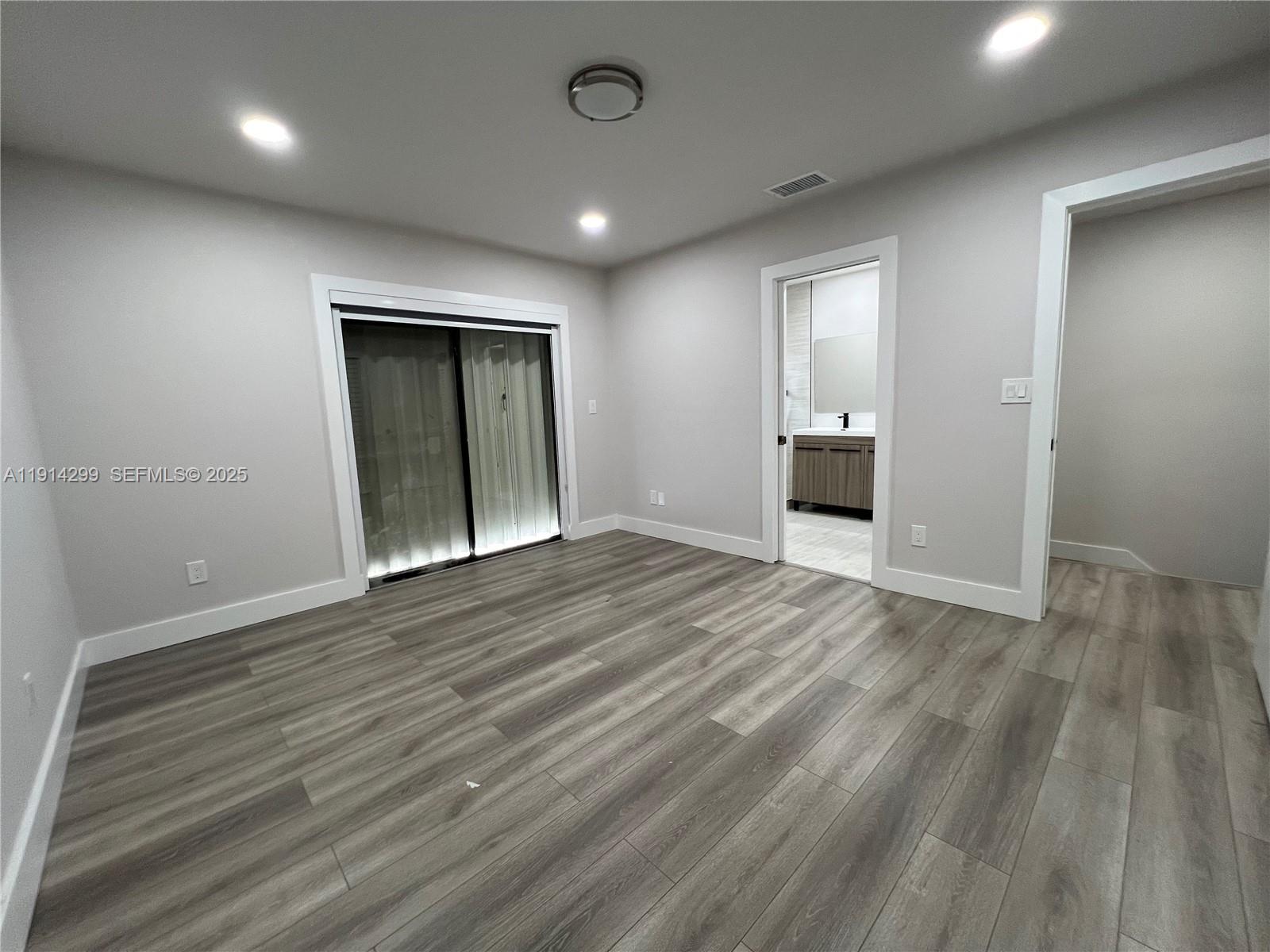 3826 Southwest 107th Avenue, Unit 22 Miami, FL 33165 - Photo 15 of 18 an empty room with wooden floor and windows