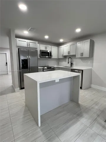 a large kitchen with stainless steel appliances kitchen island a cabinets and a counter space