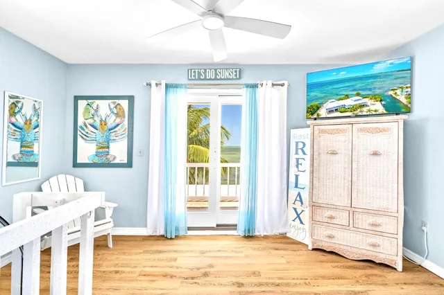 a view of a bedroom with wooden floor windows and chandelier