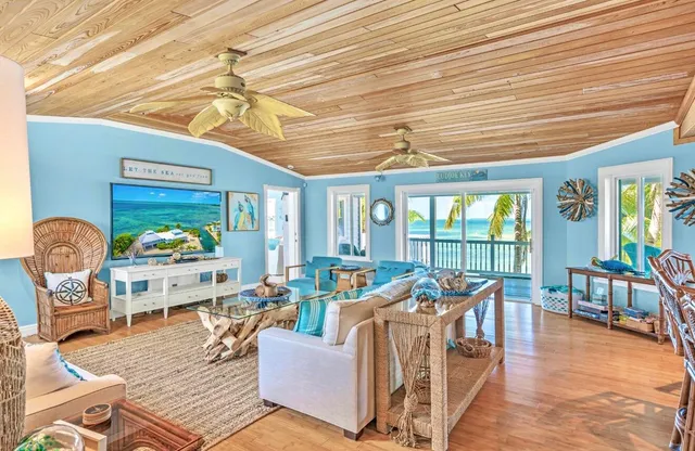 a living room with furniture floor to ceiling window and wooden floor