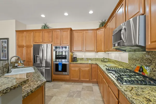 a kitchen with stainless steel appliances granite countertop a stove top oven a sink and dishwasher