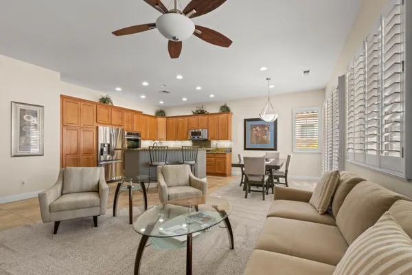 a living room with furniture kitchen view and a chandelier