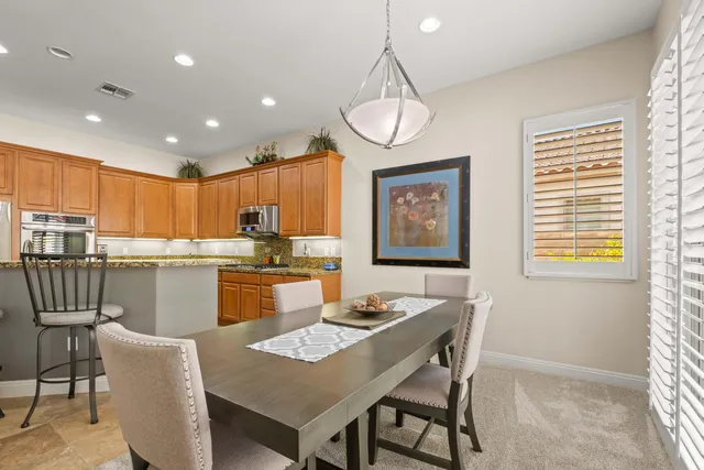 a kitchen with a dining table chairs and window