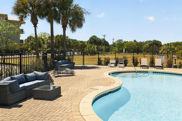 a view of a swimming pool with a couches and sky view