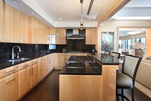 a kitchen with granite countertop a sink a counter top space stainless steel appliances and cabinets