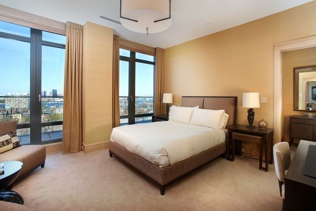 a large bed sitting in a bedroom next to a window