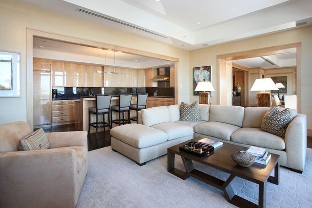 a living room with furniture and view of kitchen