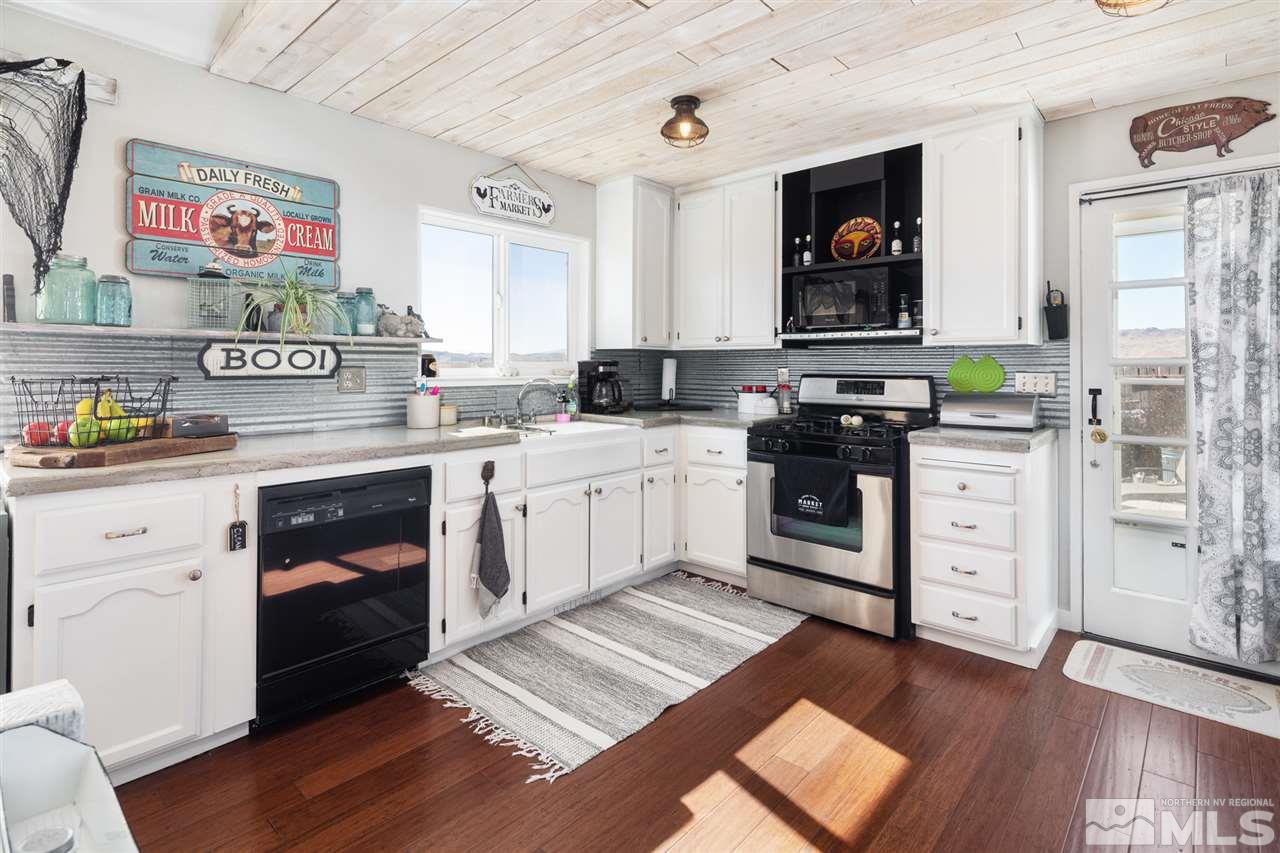 5805 Grass Valley Road Reno, NV 89510 - Photo 3 of 19 a kitchen with stainless steel appliances white cabinets and a wooden floor