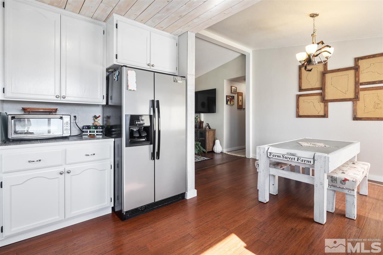 5805 Grass Valley Road Reno, NV 89510 - Photo 4 of 19 a kitchen with stainless steel appliances granite countertop a refrigerator a stove and white cabinets with wooden floor