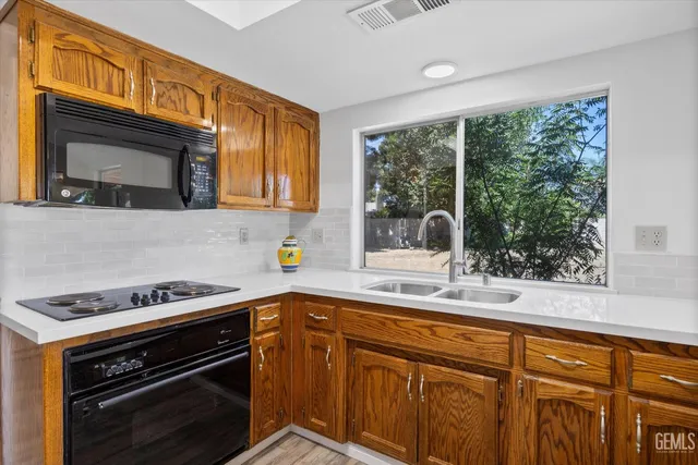a kitchen with granite countertop a stove sink and microwave