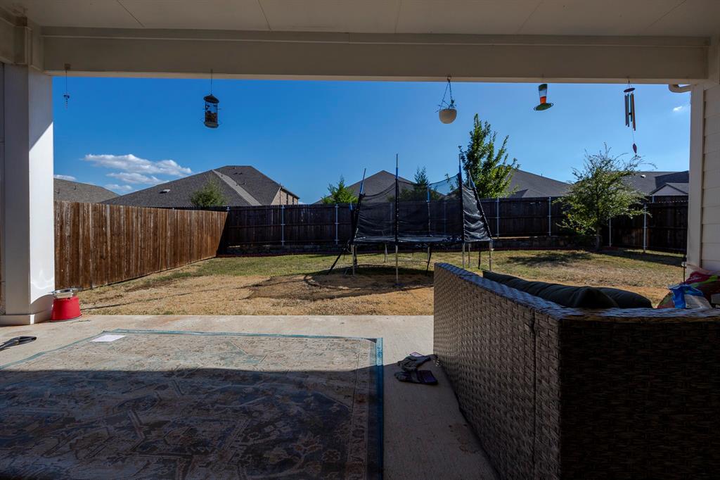 495 Fox Ridge Drive Princeton, TX 75407 - Photo 30 of 31 Covered patio with concrete flooring, opening to a fenced backyard with mature trees