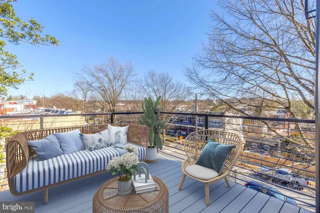 a balcony with wooden floor and outdoor seating