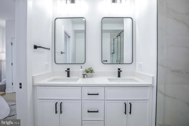 a bathroom with double vanity sinks and a mirror