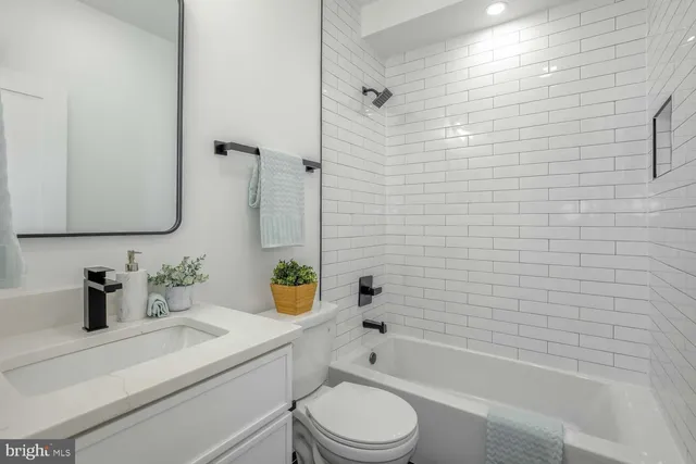 a bathroom with a sink a toilet and bathtub
