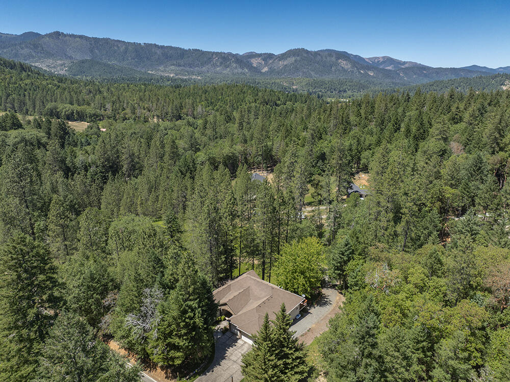 1280 Marcy Loop Road Grants Pass, OR 97527 - Photo 13 of 25 a view of a lush green hillside and a houses