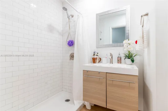 a bathroom with a bathtub shower sink and vanity