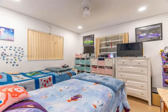 a bedroom with a bed dresser and a flat screen tv