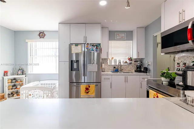 a kitchen with stainless steel appliances kitchen island granite countertop a refrigerator stove microwave and sink