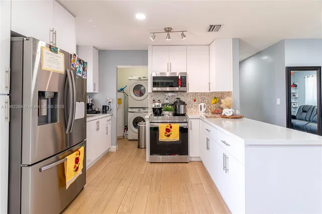 a kitchen with stainless steel appliances a refrigerator sink and microwave