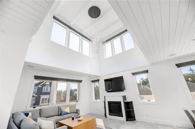 a kitchen with kitchen island a dining table chairs sink and white cabinets