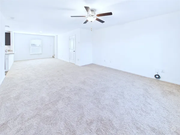 a view of a livingroom with a ceiling fan and window