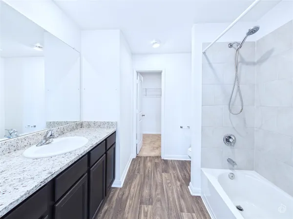 a bathroom with a granite countertop sink a toilet and shower