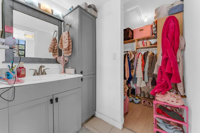 a view of walk in closet with clothes and shoes