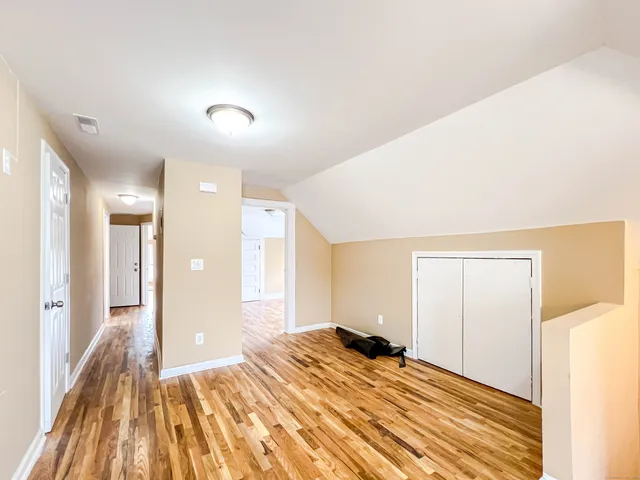 a view of a bedroom with a bed and wooden floor