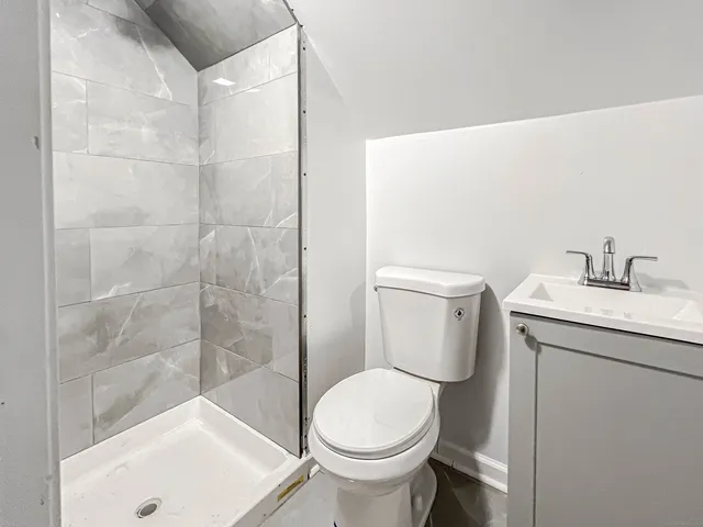 a bathroom with a sink a toilet and shower