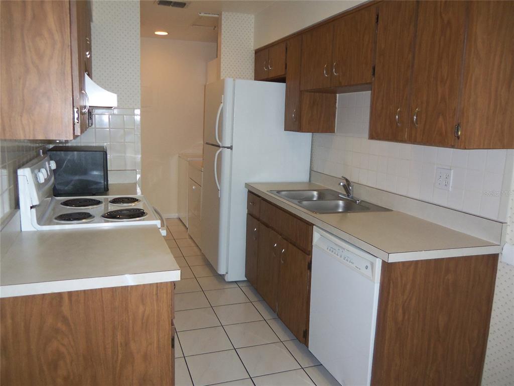 2786 Curry Ford Road, Unit 6B Orlando, FL 32806 - Photo 9 of 27 a kitchen that has a sink a stove and a refrigerator