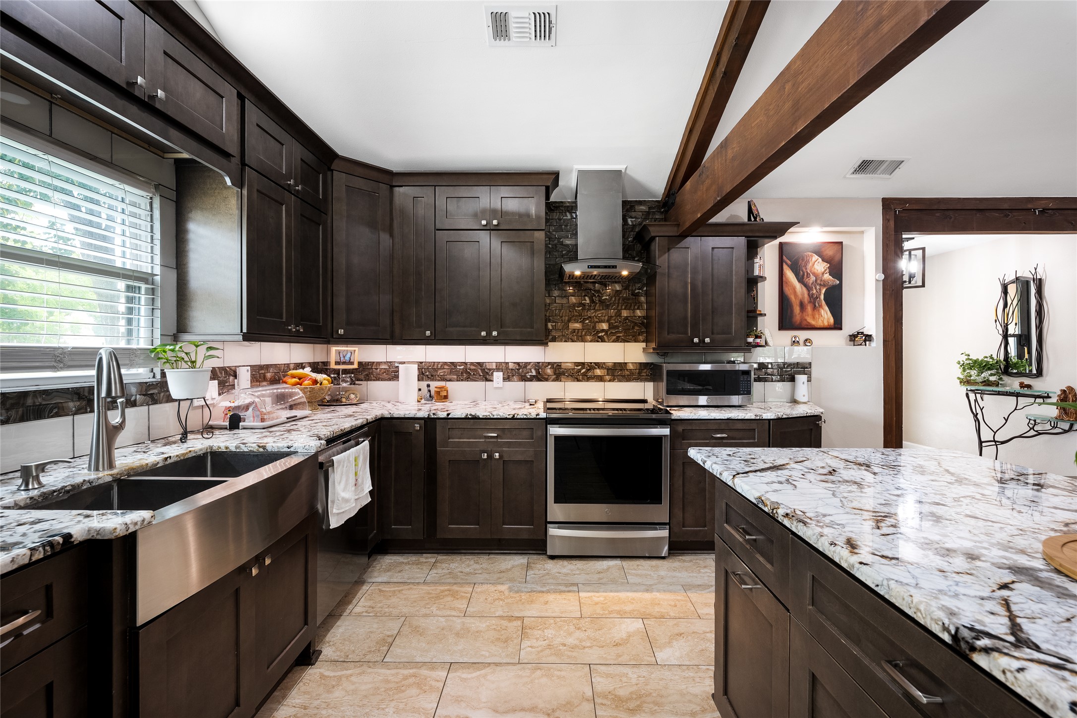 301 Oak Ridge Road Georgetown, TX 78628 - Photo 5 of 38 Kitchen featuring dark wood cabinetry, light-toned granite countertops, a stainless steel farmhouse sink, and matching stainless steel appliances