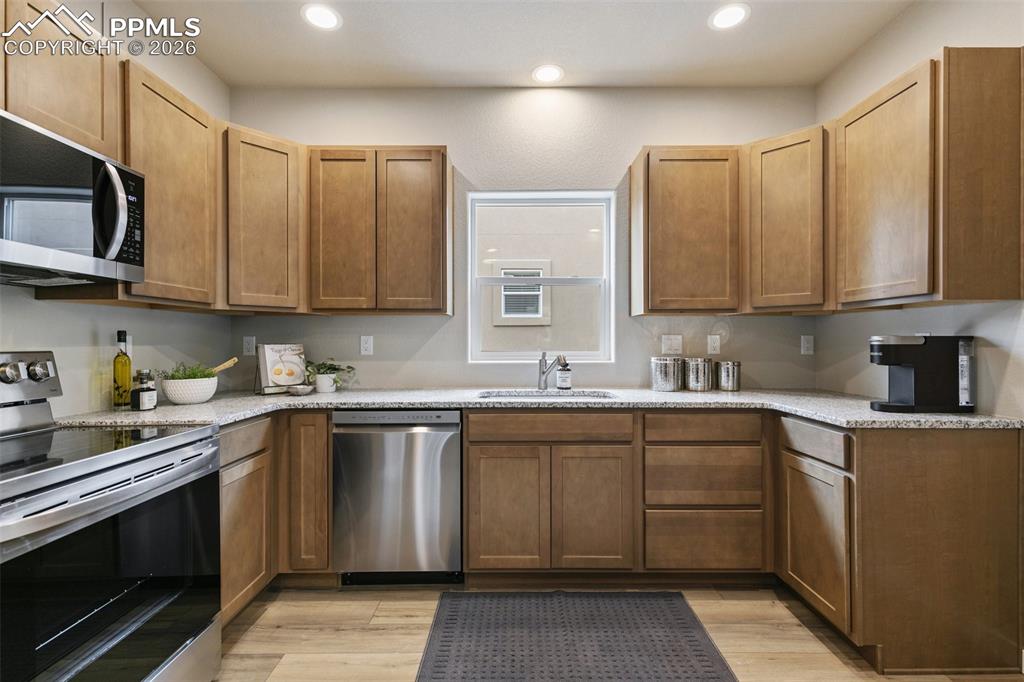 5201 Palomino Ranch Point Colorado Springs, CO 80922 - Photo 9 of 24 a kitchen with stainless steel appliances granite countertop a sink and stove top oven