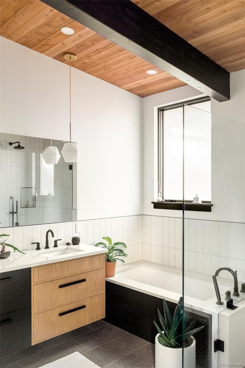 2977 Forest Street Denver, CO 80207 - Photo 11 of 23 a bathroom with a double vanity sink and a bathtub